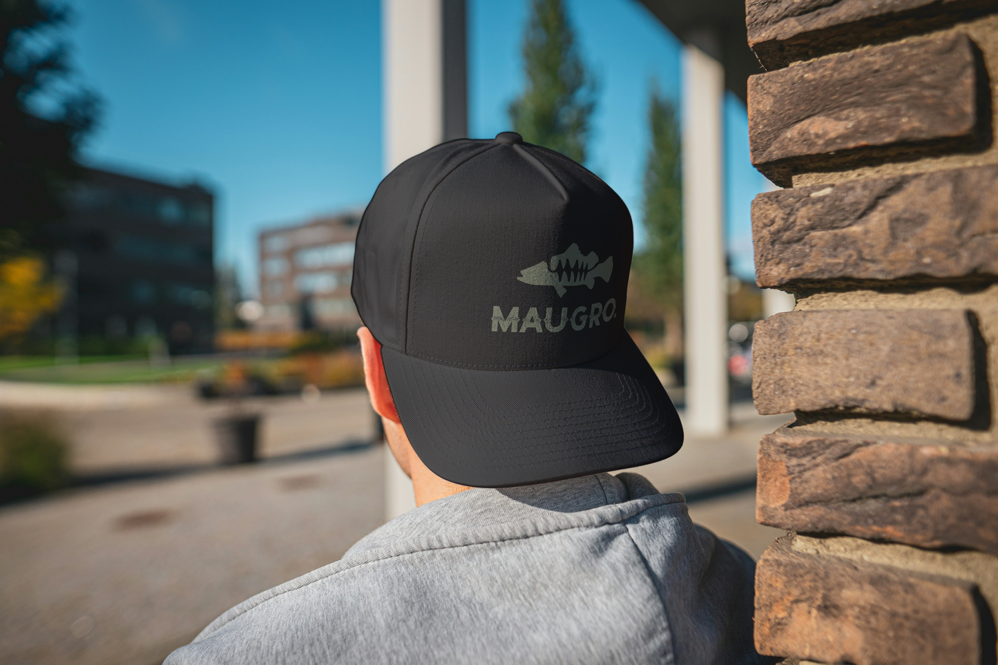 Black baseball cap with curved brim and Maugro logo in gray on back panel.