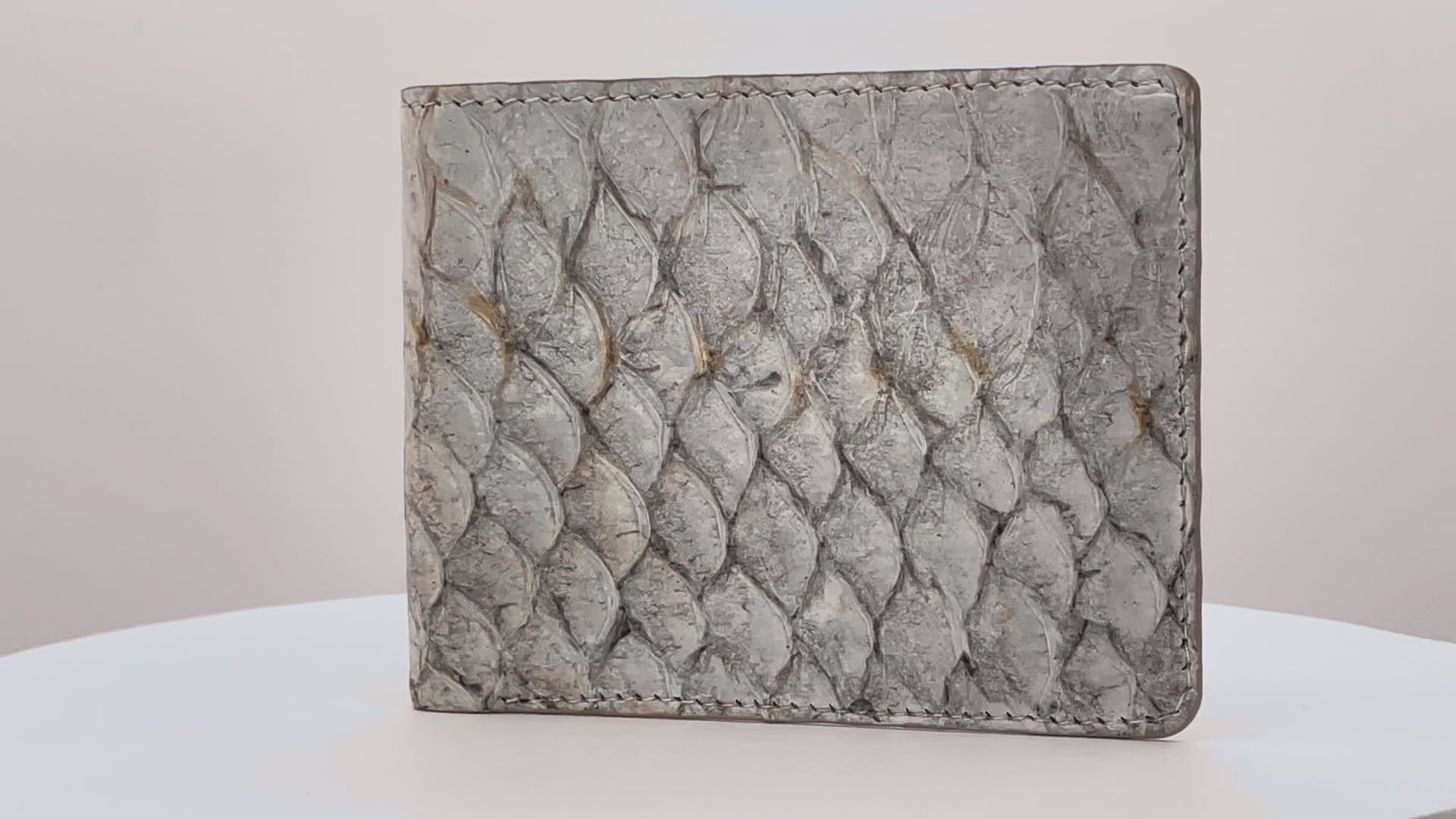 Barramundi skin wallet on a white background, brown leather interior - video
