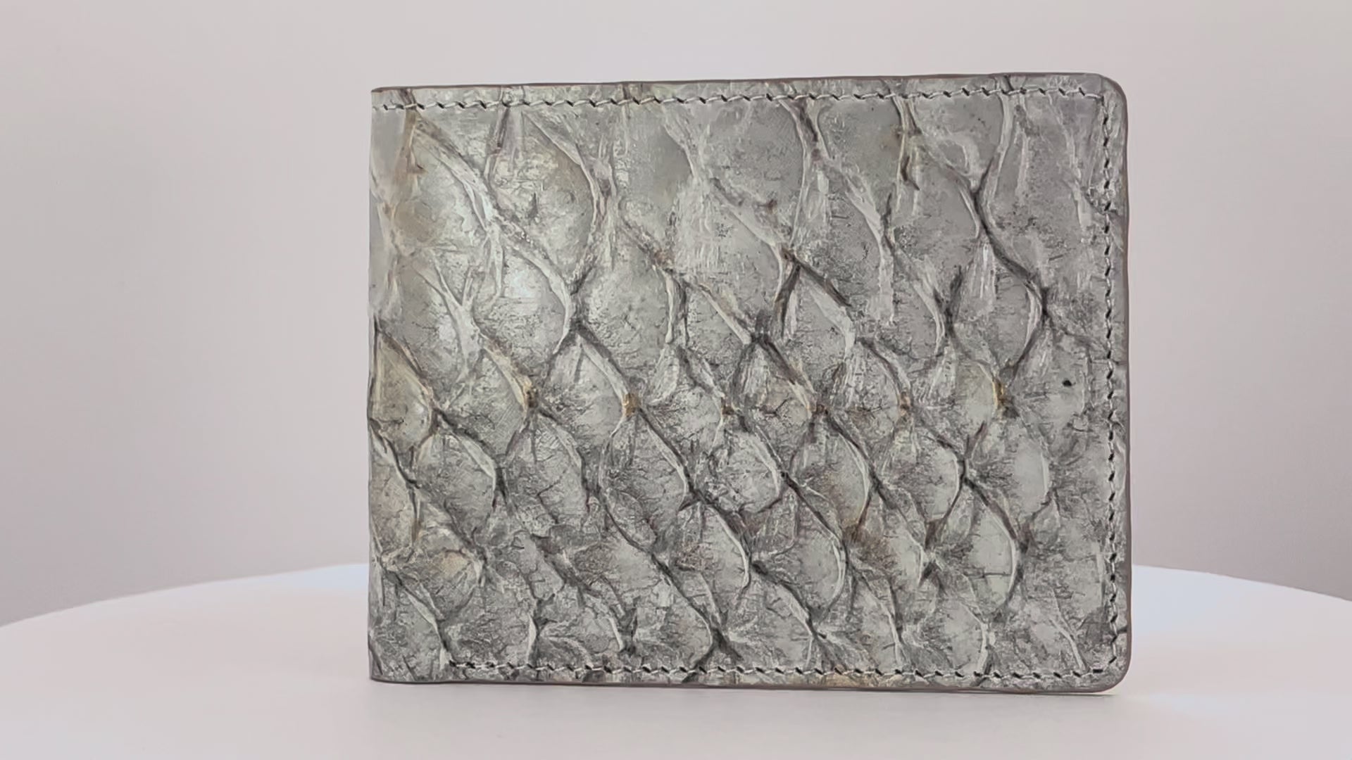 Barramundi skin wallet on a white background, brown leather interior - video